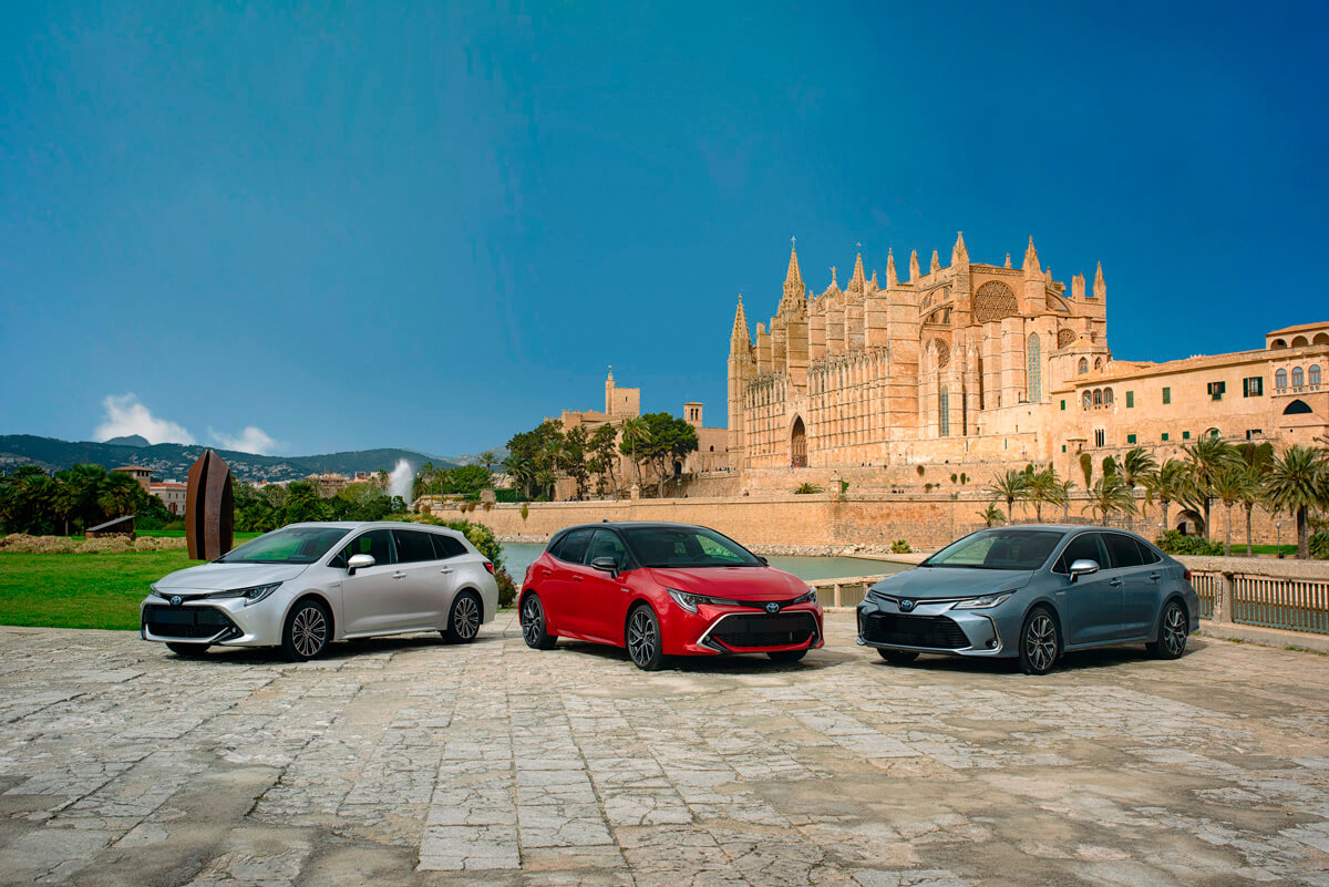 Vista de los tres Toyota Corolla con una catedral detrás